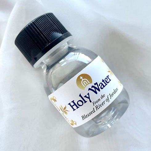 60ml small plastic vial of Holy Water from the Blessed Jordan River with a black cap, displayed on a white background.