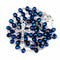 Blue rosary beads with a silver crucifix on a white background