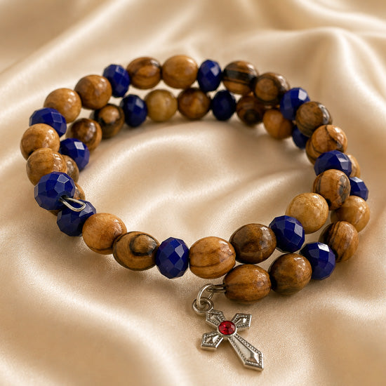Beaded wrap bracelet on display with olive wood beads, dark blue crystals, and cross charm