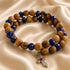 Beaded wrap bracelet on display with olive wood beads, dark blue crystals, and cross charm