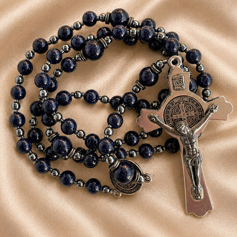 Rosary with dark navy blue lapis lazuli stones and silver-toned metal beads, featuring a silver crucifix and medallion.