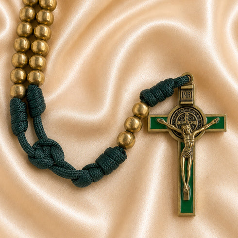 A St Benedict rosary with bronze beads on a dark green knotted cord, gold-tone crucifix with green enamel.