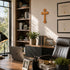 Home office with cross on the wall, wooden desk, bookshelf, and decor elements.