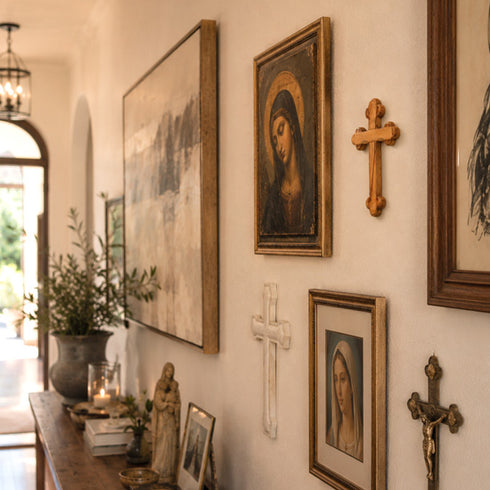 Wall with religious artwork including paintings and crosses in a home setting.