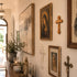 Wall with religious artwork including paintings and crosses in a home setting.