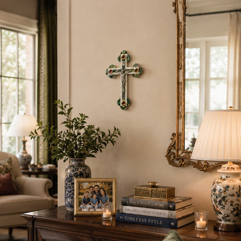 Living room with a wooden table, books, a lamp, a cross on the wall, and a mirror.