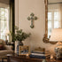 Living room with a wooden table, books, a lamp, a cross on the wall, and a mirror.