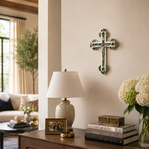 Living room with a lamp, books, and decorative cross on the wall.