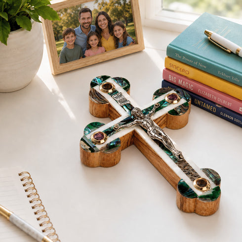 Decorative crucifix with Nacre on a table with books and framed photo.