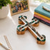 Decorative crucifix with Nacre on a table with books and framed photo.