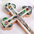 Eastern olive wood cross with crucifix, white and green Mother of Pearl decor, lying on white background with petals.
