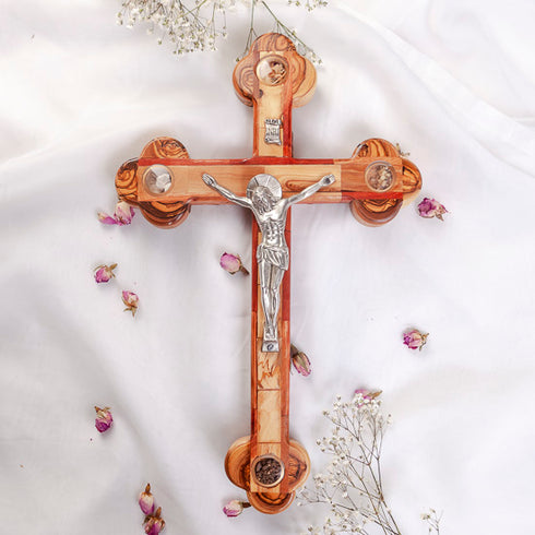 Handmade large olive wood Eastern-style cross with Holy Soil, silver crucifix, photographed on white cloth with rose petals.