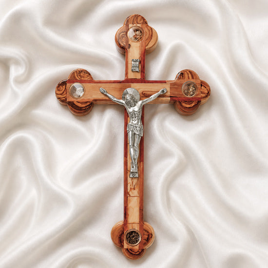 Handmade large olive wood Eastern-style cross with Holy Soil, silver crucifix, photographed on white cloth with rose petals.