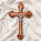 Handmade large olive wood Eastern-style cross with Holy Soil, silver crucifix, photographed on white cloth with rose petals.