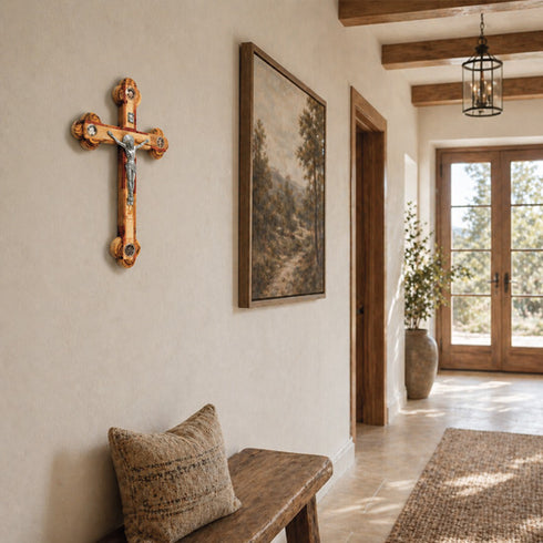 Narrow hallway with wooden cross, bench, and landscape painting on a neutral wall.