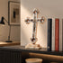 Decorative cross with corpus on a shelf with books in a room setting