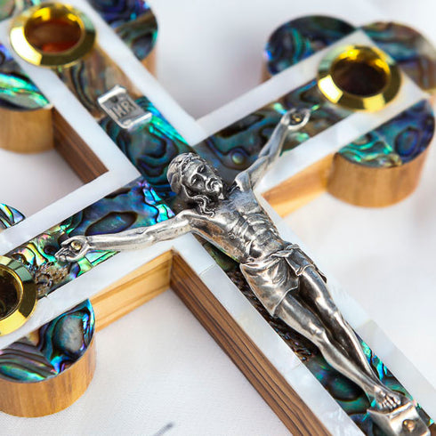 Detailed image of a budded olive wood cross with mother of pearl inlay, silver-colored crucifix, and four holy elements.