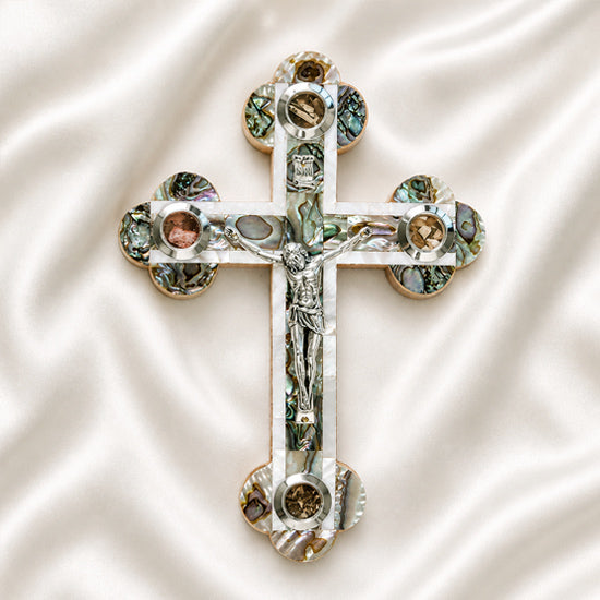 Budded olive wood cross with corpus, mother of pearl, Four Holy Land Elements on a white backdrop.