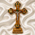 Decorative cross with a figure on a stand against a white textured background