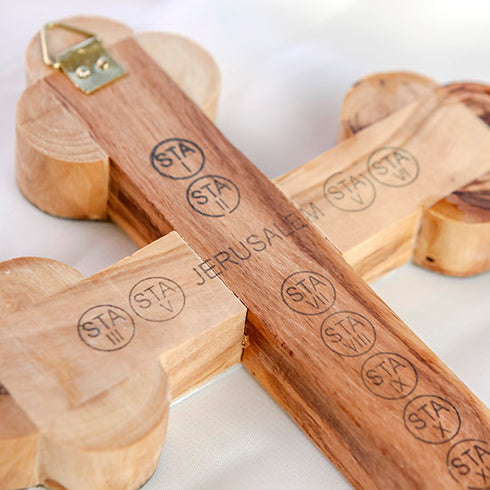 Zoomed image of the back of a budded olive wood cross with print of the word "Jerusalem" and the station of cross, with a hook to hand on the wall.