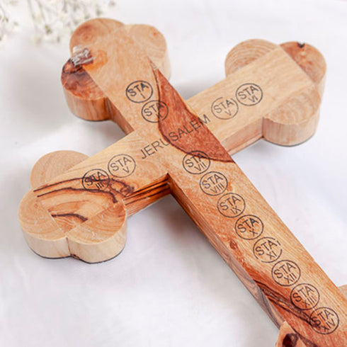 Zoomed image of the back of a handmade olive wood budded cross with "Jerusalem" and the Station of cross written on it, on a white bacground.