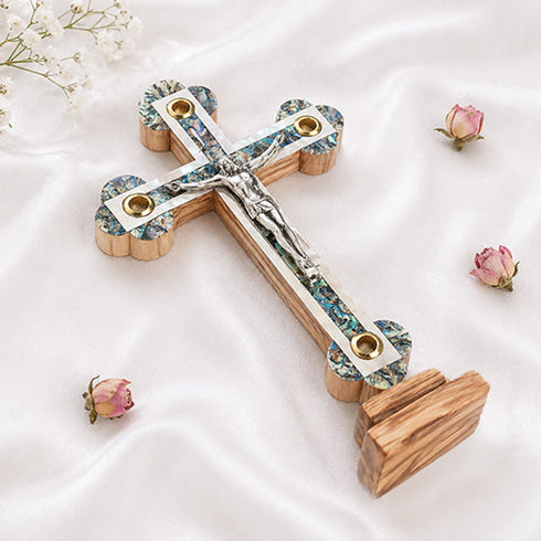 Large budded standing cross with crucifix, mother of pearl inlay and Four Elements laid on white background.