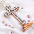 Large budded standing cross with crucifix, mother of pearl inlay and Four Elements laid on white background.