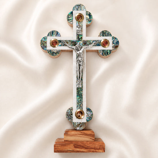 Large budded table cross with crucifix, mother of pearl inlay and Four Elements laid on white background.