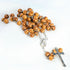 Packshot of carved olive wood rosary with silver Mary emblem centerpiece and silver crucifix.