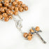 Detailed product image of carved olive wood rosary featuring Mary medallion and silver crucifix.