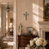 Living room with wooden dresser, religious statue, and framed pictures.