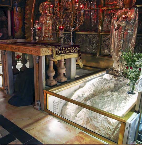 The bedrock of Golgotha, soft white limestone behind a glass protection at the Calvary.