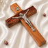 Wooden cross with a silver Jesus figure on a white fabric background