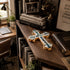 Budded cross resting on a busy wooden shelf