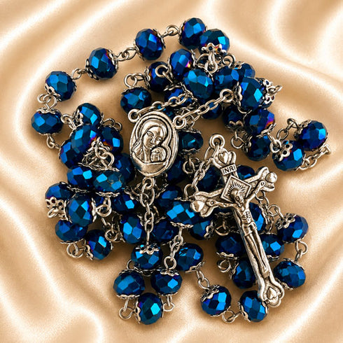 Dark blue crystal rosary, Virgin Mary centerpiece and ornate silver crucifix on champagne satin.