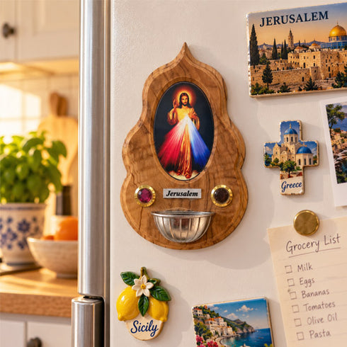 Divine Mercy olive wood holy water font displayed beside a doorway in a warm Christian home interior