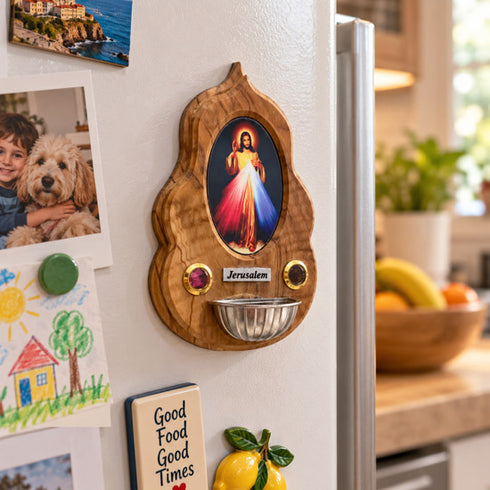 Divine Mercy olive wood holy water font attached to a refrigerator in a bright kitchen setting