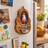 Divine Mercy olive wood holy water font attached to a refrigerator in a bright kitchen setting
