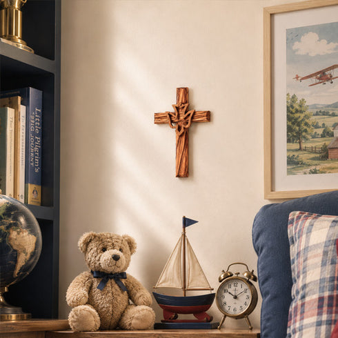 Decorative items including a teddy bear, sailboat, and clock on a shelf with a cross and framed picture in the background.