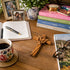 Desk with books, a cross, a cup of coffee, and a notebook.