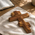 Wooden cross on a textured surface with an open book in the background