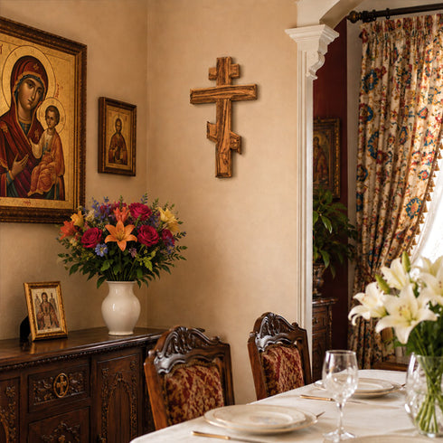 Orthodox dining room with floral arrangement, table setting, and religious artwork on the wall.