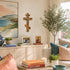 Living room with a cross, family photos, and decorative items on a cabinet.