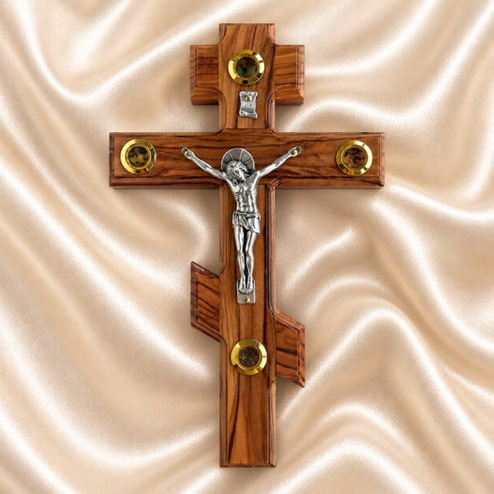 Orthodox wooden cross with Jesus Christ figure on a fabric background