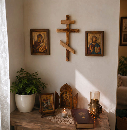 Small altar with religious icons, a cross, and candles on a wooden shelf.