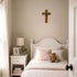 Bedroom with a bed, nightstand, and cross on the wall.
