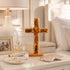 Wooden cross with engraved text on a nightstand with decorative items.