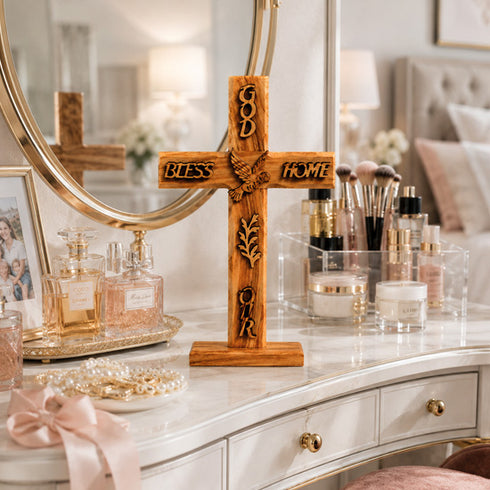 Wooden cross with engraved text on a vanity table with makeup and perfume.