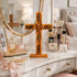 Wooden cross with engraved text on a vanity table with makeup and perfume.