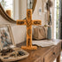 Wooden cross with engraved text on a wooden surface, surrounded by personal items.